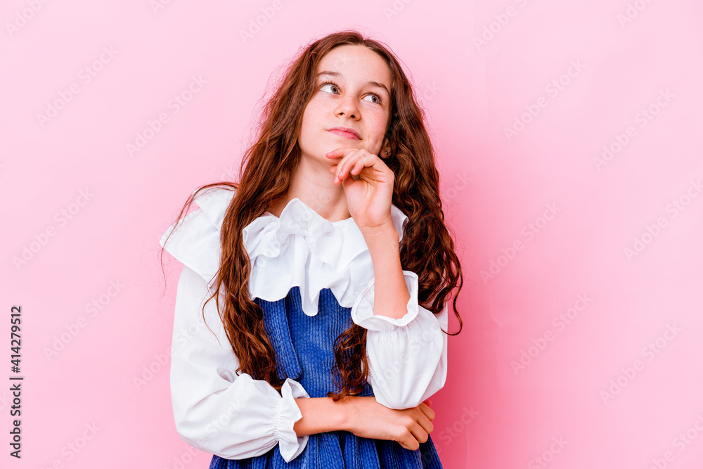 Little caucasian girl isolated on pink background thinking and looking up, being reflective, contemplating, having a fantasy. Little caucasian girl isolated on pink background thinking and looking up, being reflective, contemplating, having a fantasy.