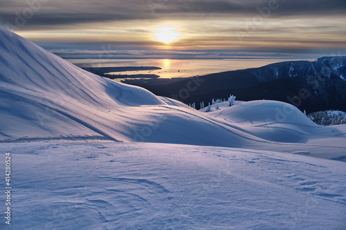 Sunset over the snow covered mountain top and ocean in winter. Mount Seymour ski resort in Vancouver. British Columbia. Canada  © aquamarine4