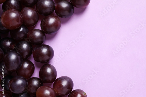 Fresh ripe juicy grapes on pink background, flat lay. Space for text