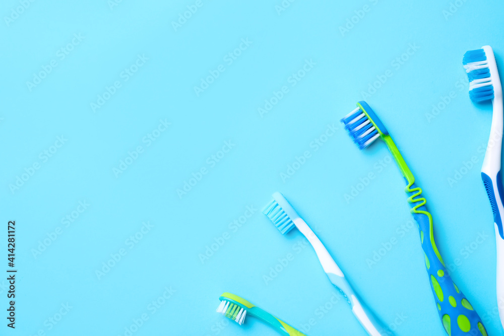 Different toothbrushes and space for text on light blue background, flat lay Different toothbrushes and space for text on light blue background, flat lay
