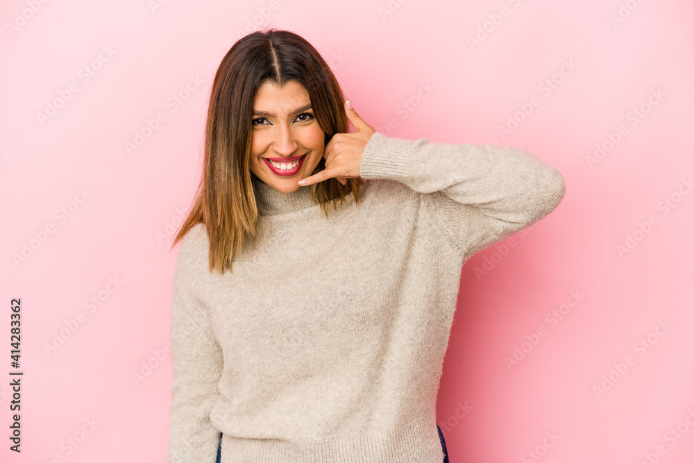 Young indian woman isolated on pink background showing a mobile phone call gesture with fingers. Young indian woman isolated on pink background showing a mobile phone call gesture with fingers.