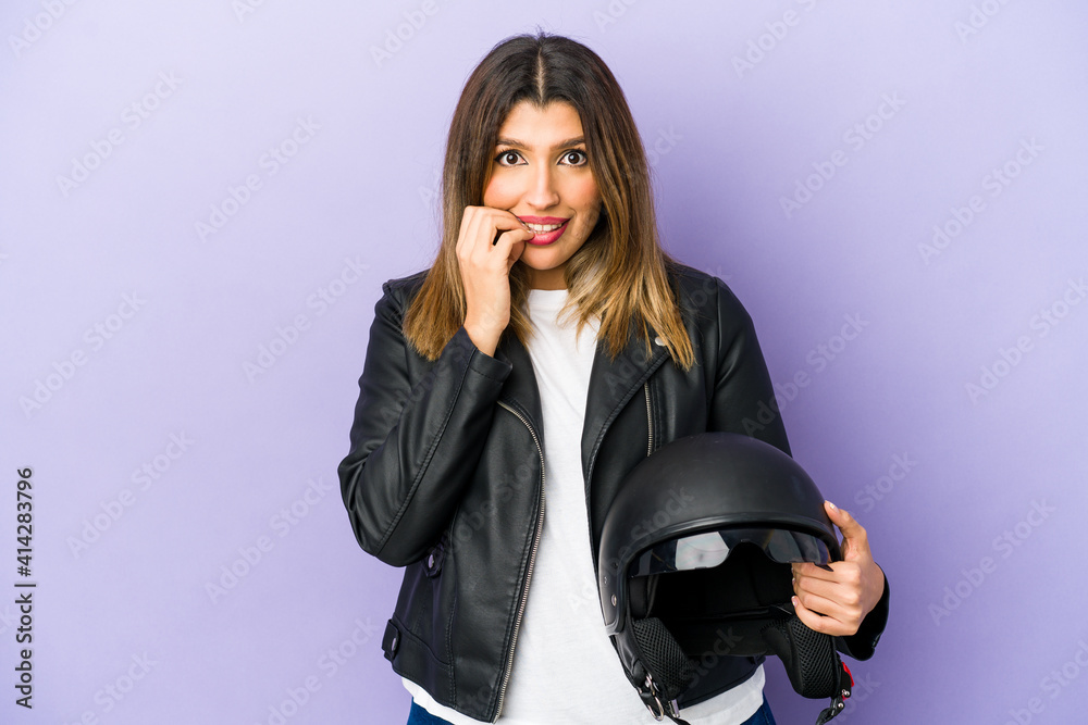 Young indian motorbiker woman isolated biting fingernails, nervous and very anxious. Young indian motorbiker woman isolated biting fingernails, nervous and very anxious.
