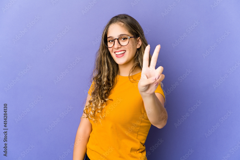Young caucasian cute woman showing victory sign and smiling broadly. Young caucasian cute woman showing victory sign and smiling broadly.