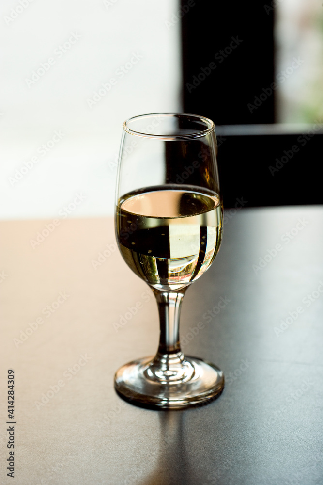 Glass of White Wine on a Table with Reflections Glass of White Wine on a Table with Reflections