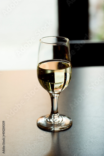 Glass of White Wine on a Table with Reflections