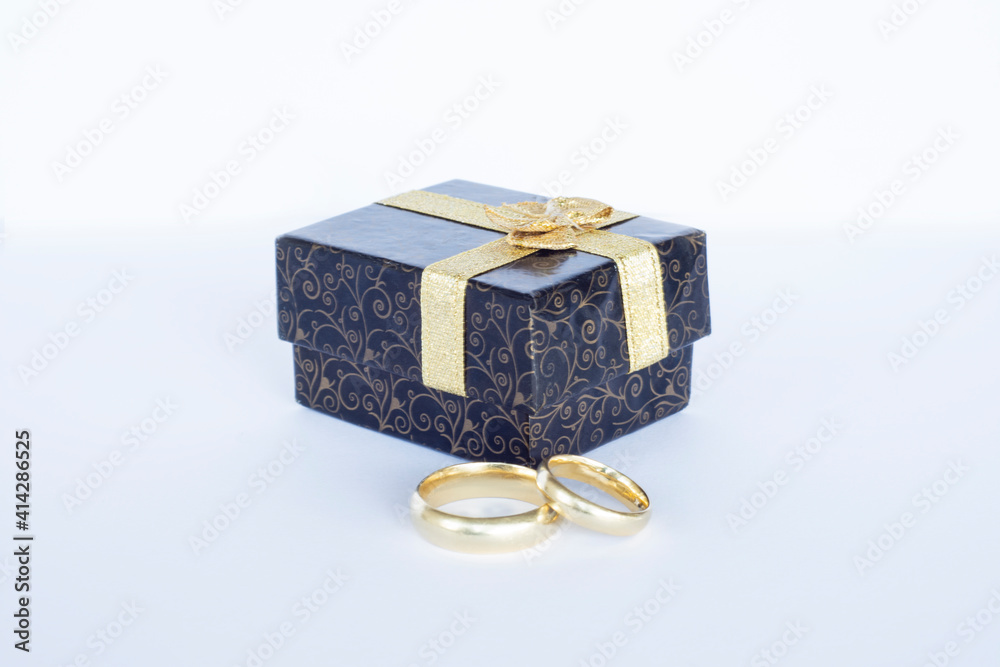 Wedding Rings and Little Jewelery Box. mall cardboard box decorated with gold ribbons and a pair of gold wedding rings Wedding Rings and Little Jewelery Box. mall cardboard box decorated with gold ribbons and a pair of gold wedding rings