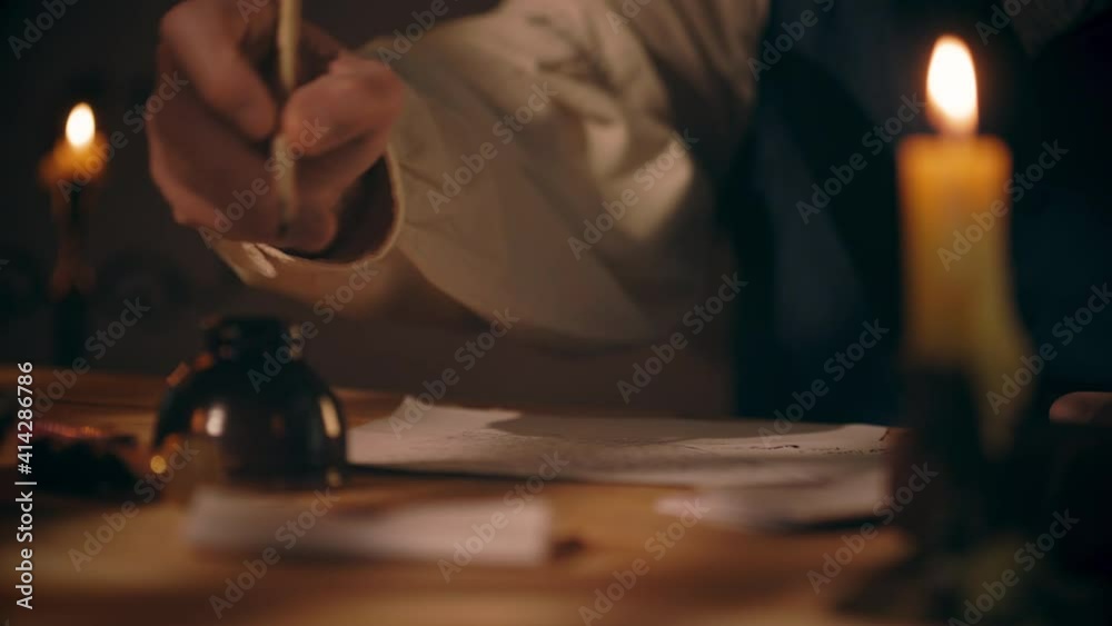 An 18th century scene tracks across a desk lit by candlelight and overhead window light of a man writing a letter using a feather quill pen. An 18th century scene tracks across a desk lit by candlelight and overhead window light of a man writing a letter using a feather quill pen.