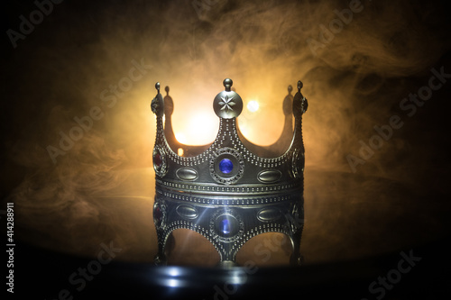 low key image of beautiful queen/king crown over wooden table. vintage filtered. fantasy medieval period