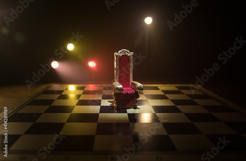 Red royal chair miniature on wooden table. Medieval Throne on chessboard. Chess board game concept of business ideas and competition and strategy ideas concept.