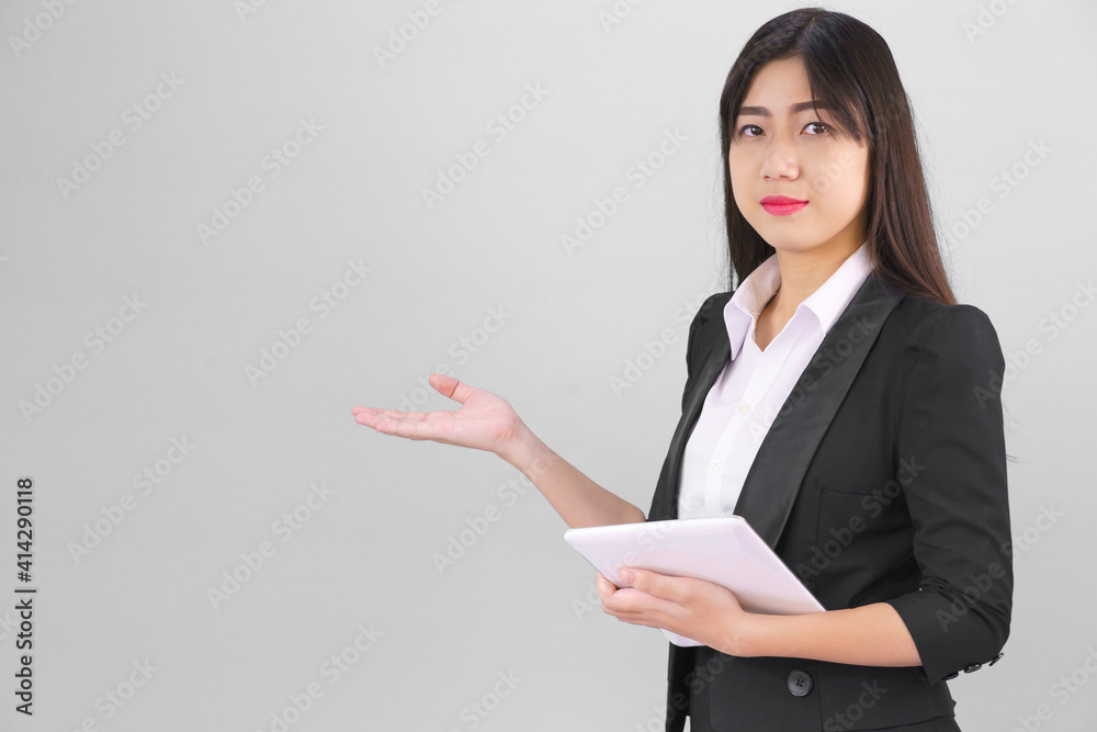 Asain women in suit standing using digital tablet and pointing finger Asain women in suit standing using digital tablet and pointing finger