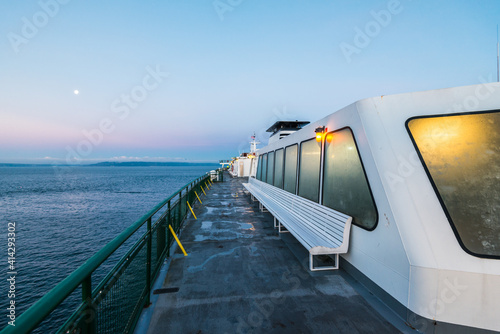 Chilly morning ferry ride view from upper deck as the boat crosses calm waters with a pastel perfect dawn sky reaching to the horizon