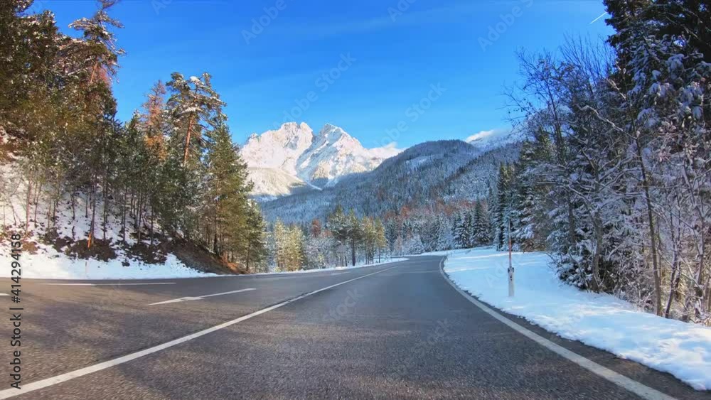 Beautiful winter landscape POV vehicle drive, forest evergreen trees, mountains snow peaks, asphalt road and sunny blue sky, car travel gopro point of view Beautiful winter landscape POV vehicle drive, forest evergreen trees, mountains snow peaks, asphalt road and sunny blue sky, car travel gopro point of view