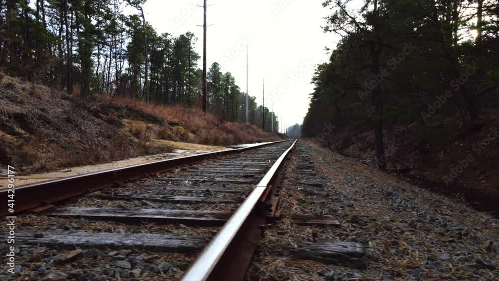 Old rustic train track, railroad leading into the horizon with trees and nature landscape 