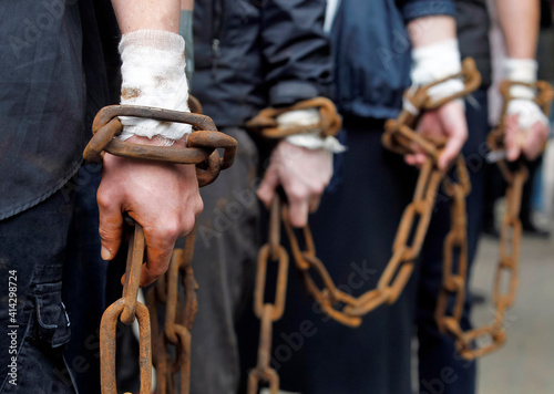 chain on hands of chained together men close up