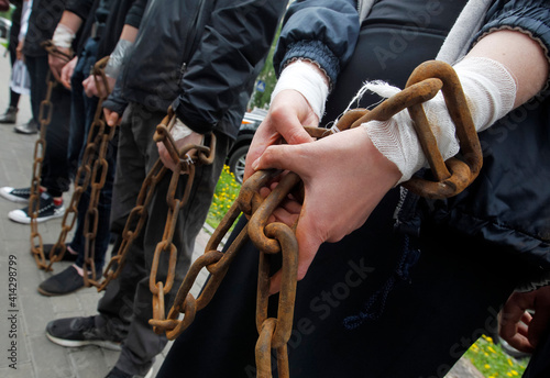 group of people stand with chained hands close-up