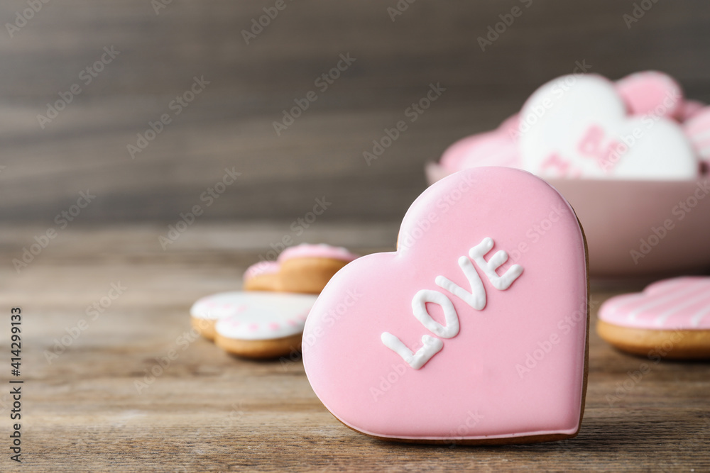Heart shaped cookie with word Love on wooden table, closeup and space for text. Valentine's day treat Heart shaped cookie with word Love on wooden table, closeup and space for text. Valentine's day treat