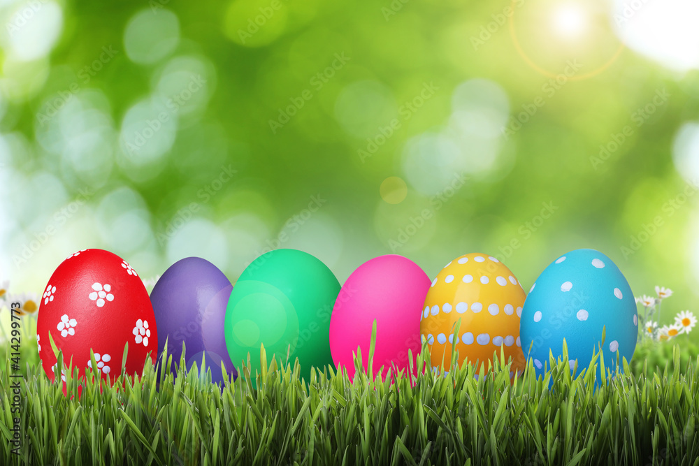 Bright Easter eggs on green grass outdoors
