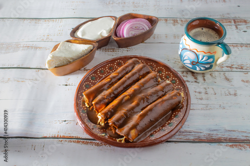 Enchiladas or mole wraps with a Mexican cup of coffee, purple onion, cream and fresh cheese. Mexican food, Mexican coffee photo