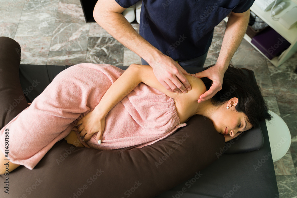 Relaxed pregnant woman receiving a back massage