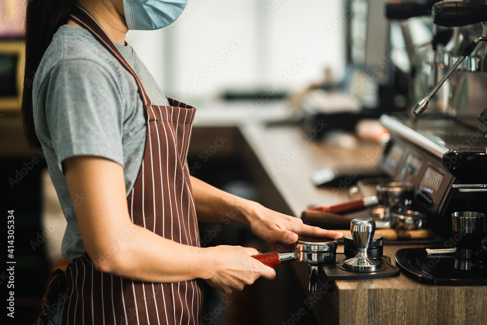 Close up view of barista is preparing to grind the coffee beans for making espresso coffee professional. Close up view of barista is preparing to grind the coffee beans for making espresso coffee professional.