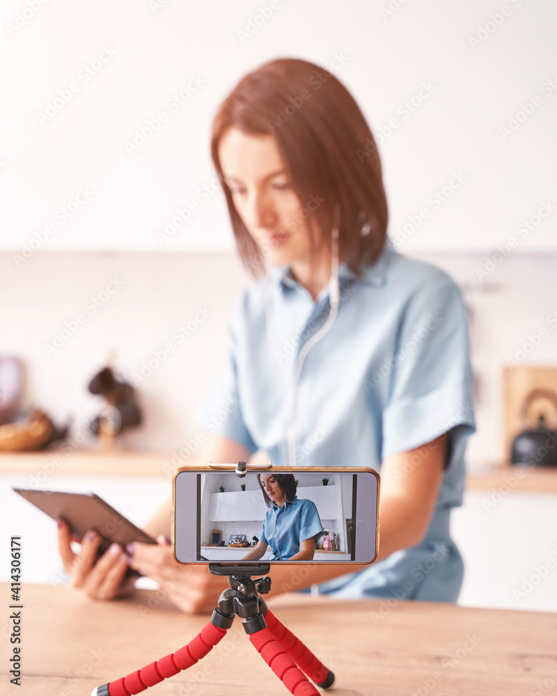Young woman record video at kitchen. Self portrait in home. Blogger selfie video. Female person. Lifestyle action. Pretty posing. Lifestyle. Online study Young woman record video at kitchen. Self portrait in home. Blogger selfie video. Female person. Lifestyle action. Pretty posing. Lifestyle. Online study