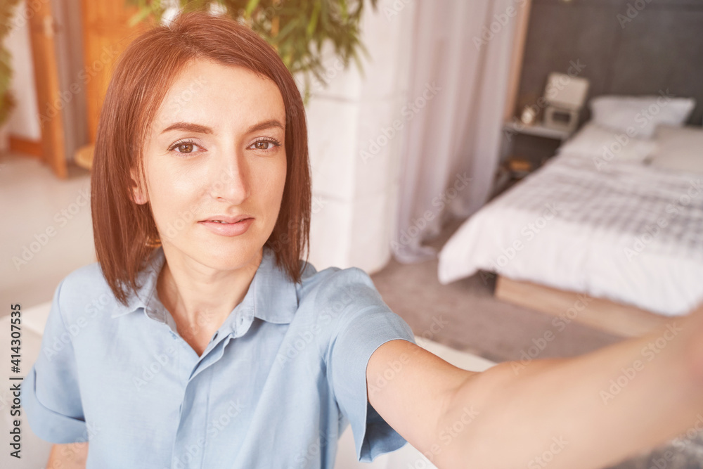 Young woman doing self portrait inside home. Blogger selfie video. Happy emotion. Smiling female person. Lifestyle action. Pretty posing Young woman doing self portrait inside home. Blogger selfie video. Happy emotion. Smiling female person. Lifestyle action. Pretty posing