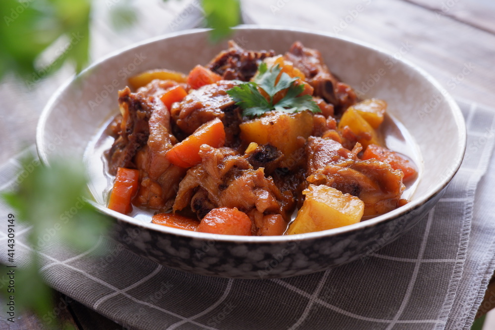 a plate of chicken stew with carrot and potato on a wooden table a plate of chicken stew with carrot and potato on a wooden table