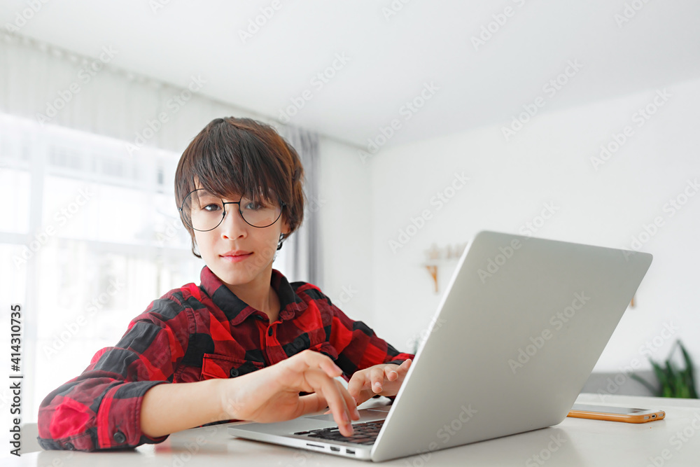 Kid boy with glasses learning at home on laptop for school. Adorable child making homework Kid boy with glasses learning at home on laptop for school. Adorable child making homework