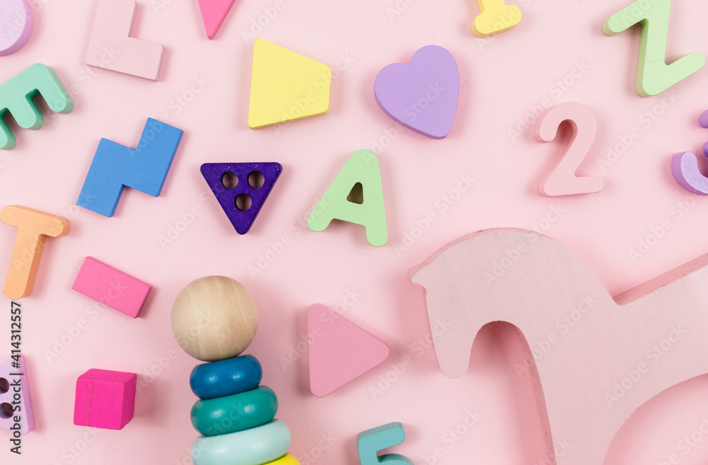 Wooden pyramid, toys, a horse on pastel pink background. Trendy cute baby first toys. Eco-friendly, plastic-free set of accessories for kids. Toys for kindergarten, preschool or daycare. Close up Wooden pyramid, toys, a horse on pastel pink background. Trendy cute baby first toys. Eco-friendly, plastic-free set of accessories for kids. Toys for kindergarten, preschool or daycare. Close up