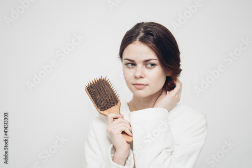 woman holding a comb in her hand and tangled hair fragility health problems