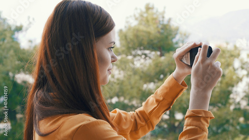 woman with phone in hand in nature taking pictures of nature outdoors