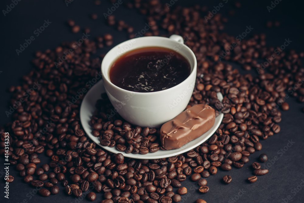 a cup of coffee and a chocolate bar on a saucer arabica beans variety drink a cup of coffee and a chocolate bar on a saucer arabica beans variety drink