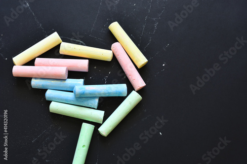 A top view image of colorful sidewalk chalk on a black background. 