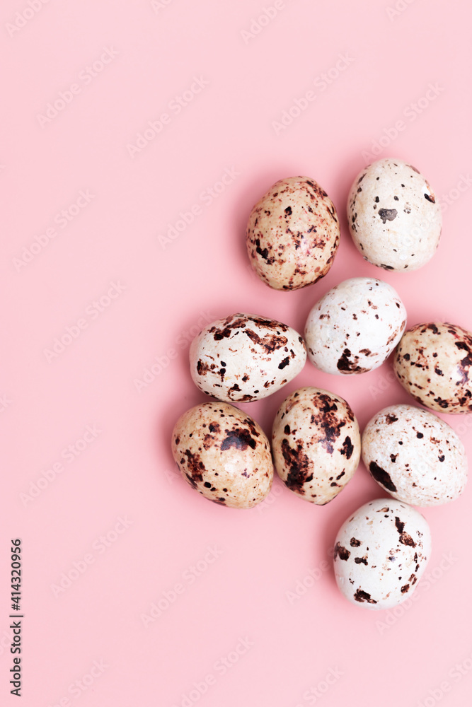Chocolate Quail eggs on pastel background. Small pink egg, spring Easter holiday, pastel colors.