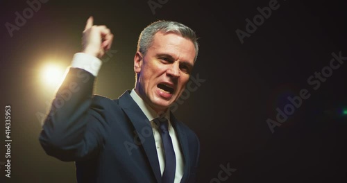 Aggressive man speaking about politics from stage photo