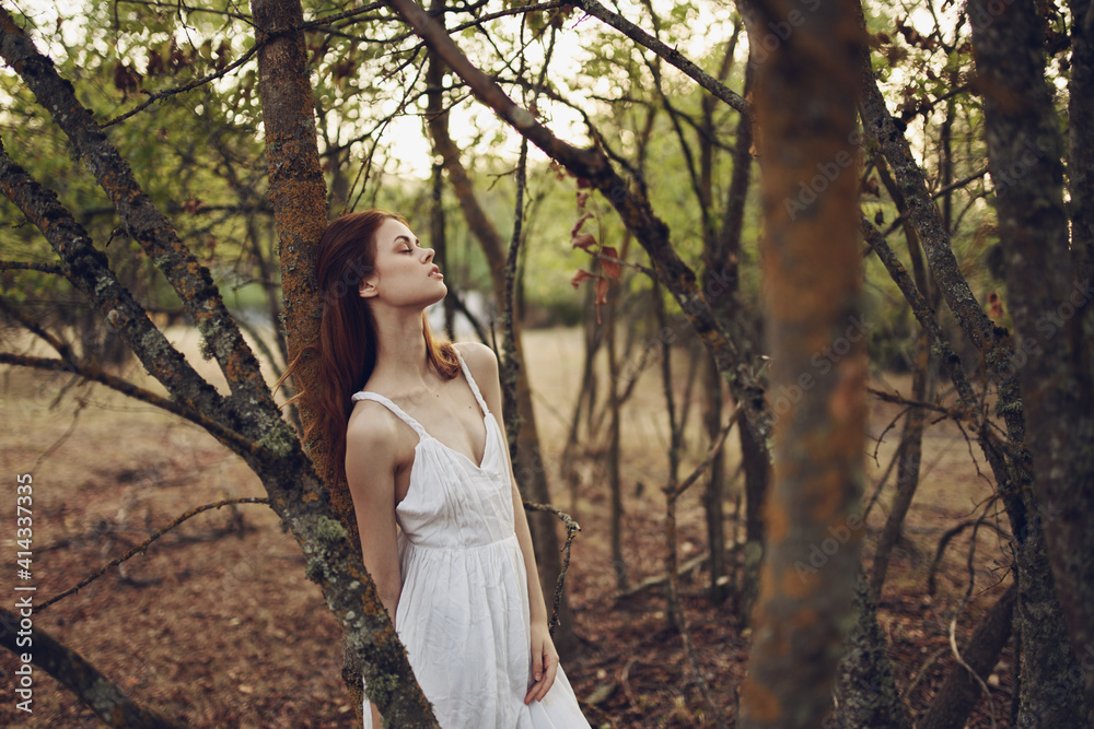 sexy woman in white summer dress near trees in the garden sexy woman in white summer dress near trees in the garden