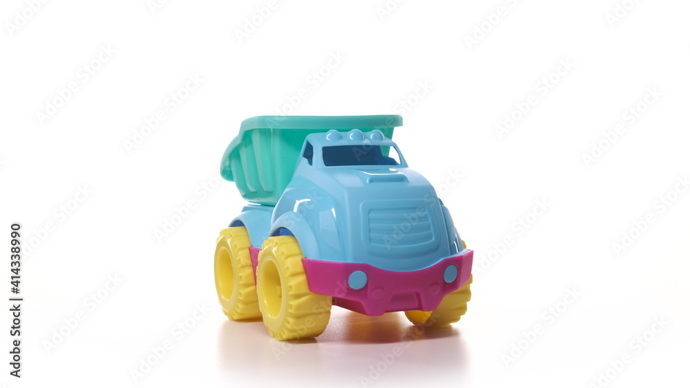 Fototapeta premium Toy car isolate on white background. Toy truck turquoise blue yellow and red color on turntable spin.