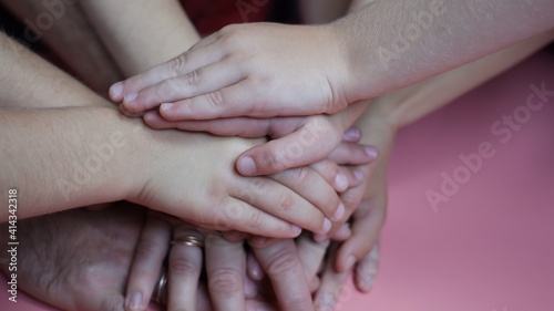 A friendly family will join hands on a pink background.