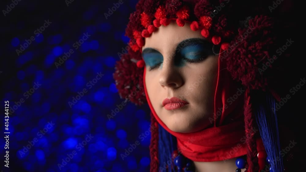 Woman in futuristic ethnic outfit makeup at light glare disco. Medium close up shot on 4k RED camera Woman in futuristic ethnic outfit makeup at light glare disco. Medium close up shot on 4k RED camera