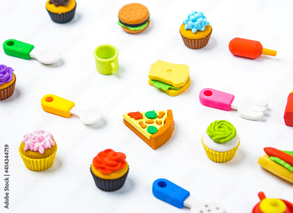 View of miniature toy kitchenware and foods on white background. Image with selective focus and flat lay. View of miniature toy kitchenware and foods on white background. Image with selective focus and flat lay.