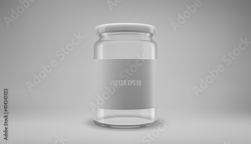 Glass jam jar with a lid. A transparent jar with a white lid and label.