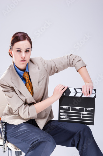 Portrait of Serious Caucasian Female Posing in Beige Blazer in Chair with Actioncut Indoors. photo