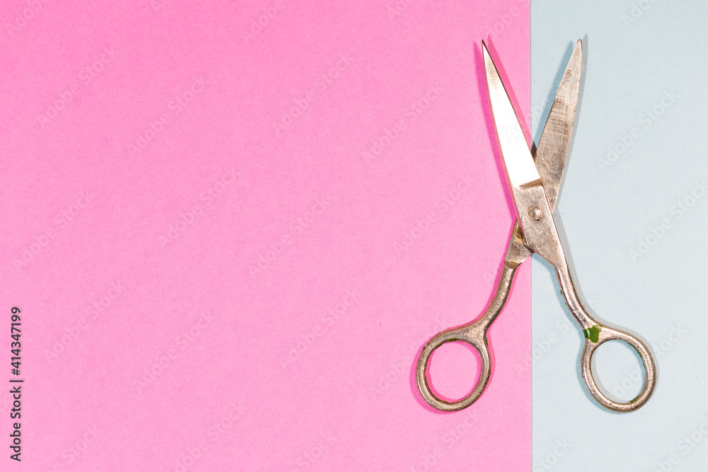 Pair of Old Used Metal Rusty Scissors Placed Over Pink And Blue Paper Background. Pair of Old Used Metal Rusty Scissors Placed Over Pink And Blue Paper Background.