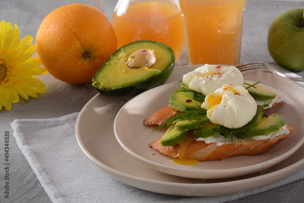 Poached eggs and sandwiches with avocado. Sliced avocado and egg on toasted bread for healthy breakfast or snack