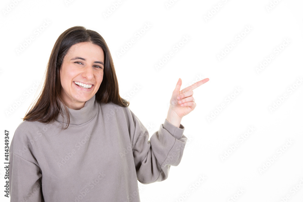 young woman pointing aside copy space smiling over white background young woman pointing aside copy space smiling over white background