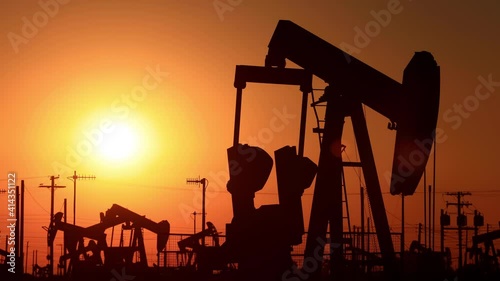The sun rises behind oil pumps in California