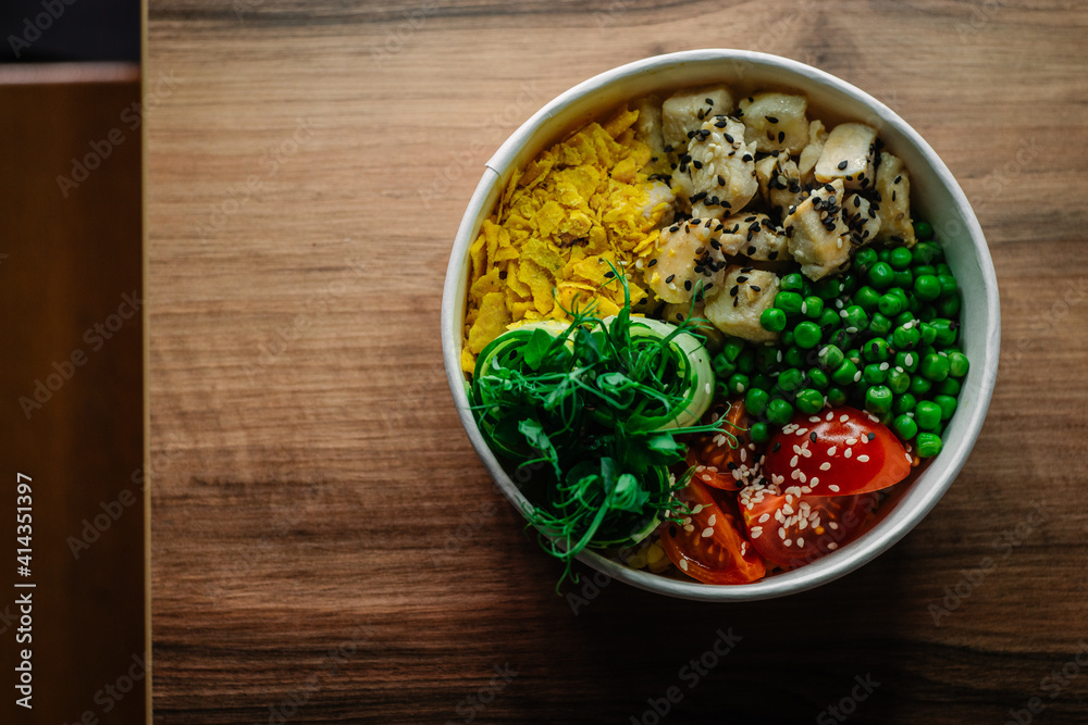 Bowl with chicken on wooden table