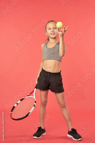 Cheerful girl holding racket and playing with tennis ball © Friends Stock