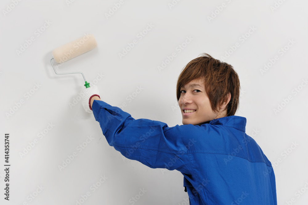 壁を塗る若い職人 壁を塗る若い職人