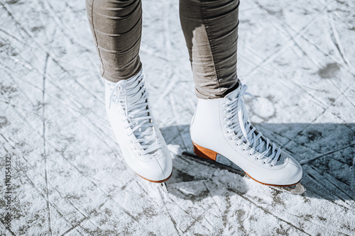 Fotografia Young woman ice skating outdoors on a pond on a freezing winter day